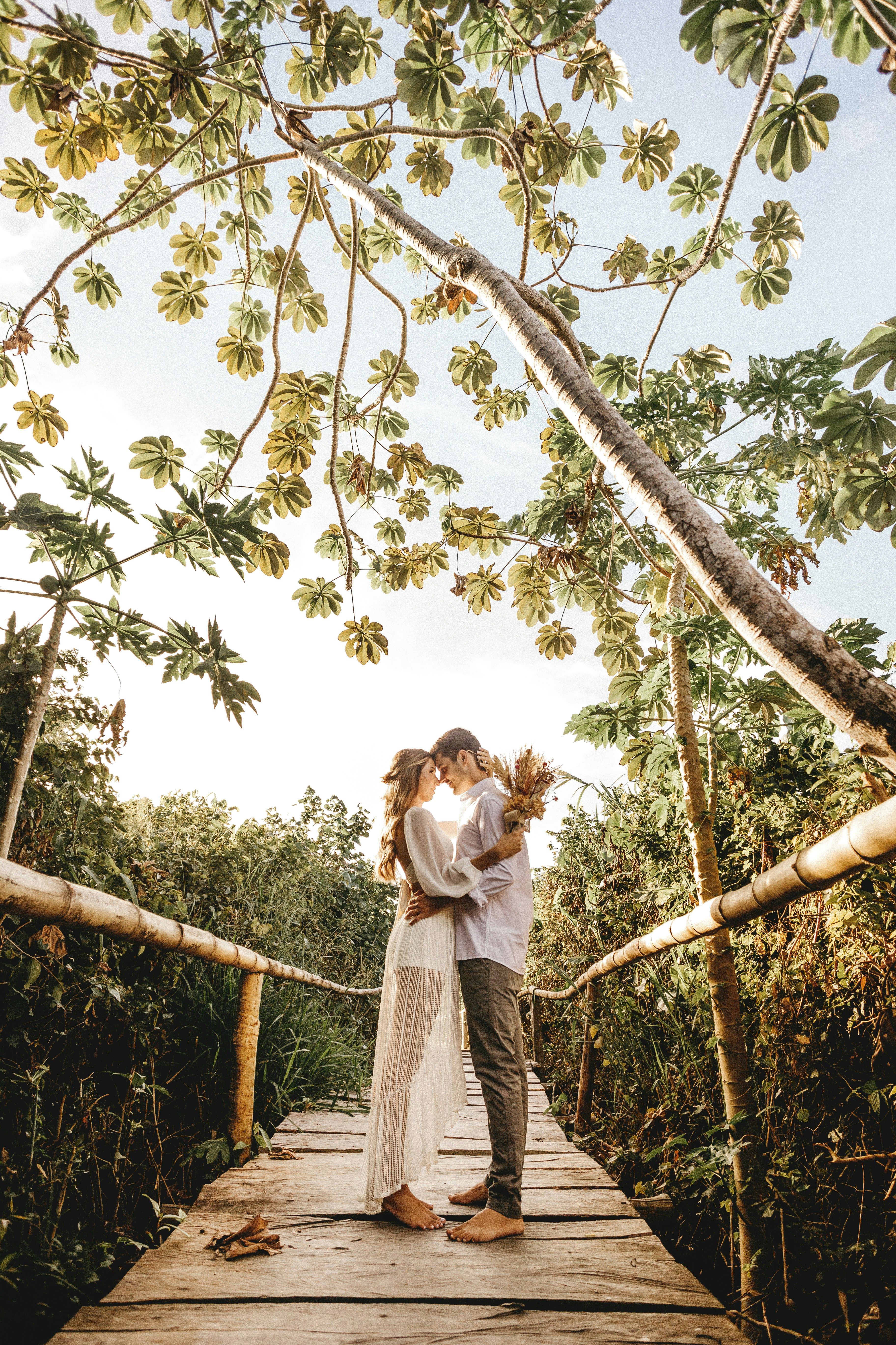 woman in white dress standing on tree branch during daytime